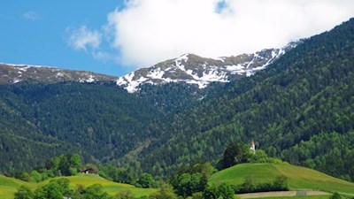 Das idyllische Karnol mit dem Leonharder Kreuz im Hintergrund